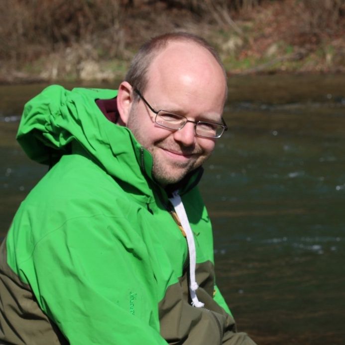 Portraitbild von Pascal Vonlanthen sitzend an einem Fluss